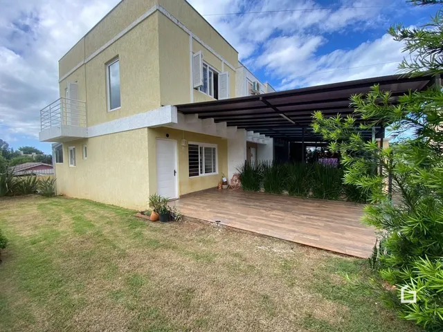 Fachada de uma casa em Lajeado, Brasil com área externa de madeira e gramado.
