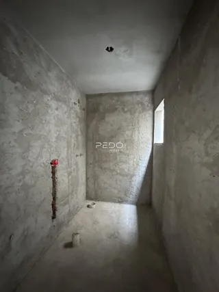 Corredor interno com paredes de concreto cru.