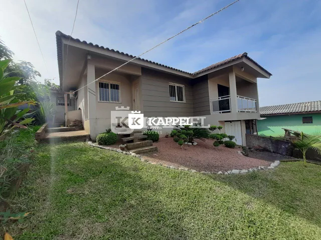 Fachada de uma casa em Lajeado, Brasil, com gramado verde e paisagismo.