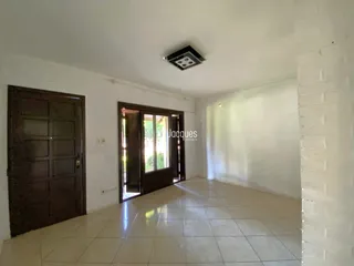 Hall com piso de cerâmica e portas de madeira na área interna.