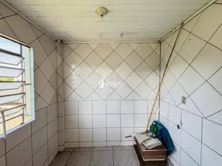 Parede interna com revestimento de azulejos brancos e uma janela.