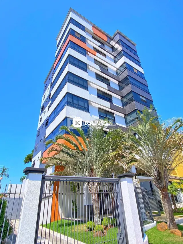 Fachada de um prédio residencial moderno com vegetação e palmeiras.