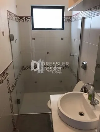 Foto de um banheiro com revestimento cerâmico branco.