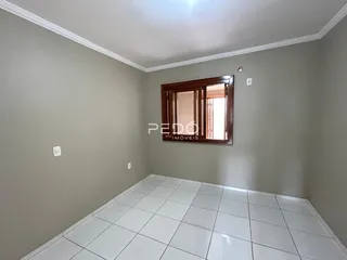Vista interna de um cômodo com piso de cerâmica e parede cinza claro.