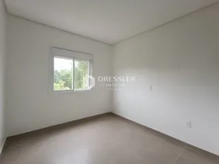 Foto de um cômodo interno com paredes brancas e piso de cerâmica.