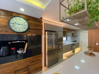 Interior de uma sala de estar com detalhes em madeira e cozinha moderna.