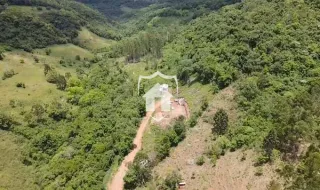 Vista aérea de uma propriedade em Lajeado, Brasil, cercada por vegetação densa.