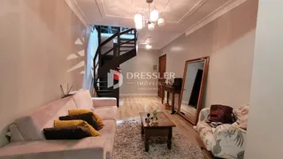 Sala de estar com sofá e escadaria em um imóvel no Brasil.
