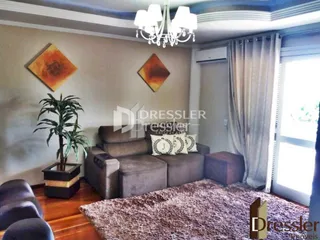 Sala de estar com sofá e piso de madeira em um imóvel no Brasil.