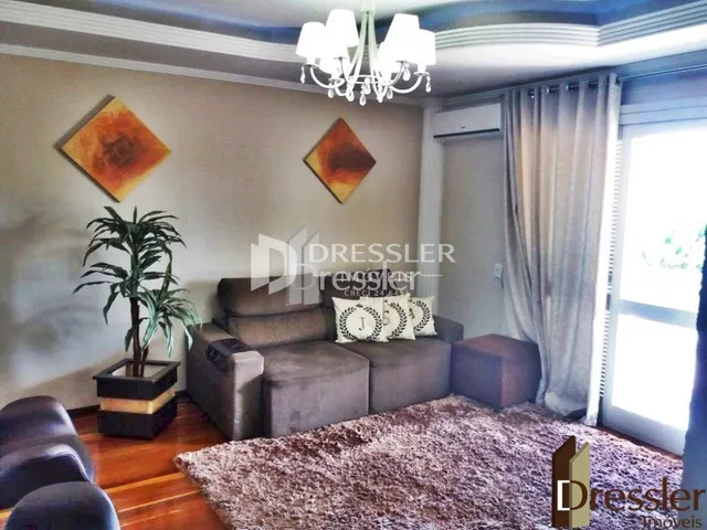 Sala de estar com sofá e piso de madeira em um imóvel no Brasil.