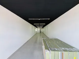 Corredor longo e iluminado de um imóvel.