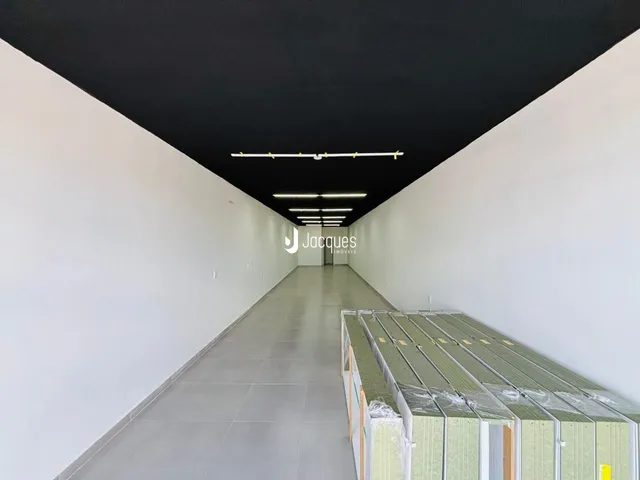 Corredor longo e iluminado de um imóvel.