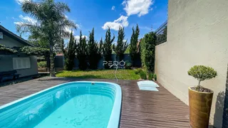 Foto de uma piscina e deck de madeira em uma propriedade.