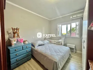 Quarto com cama e cômoda azul em um ambiente claro.