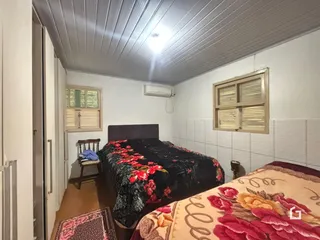Quarto com cama e janela em imóvel no Brasil.