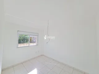 Vista interna de uma sala com paredes brancas e piso de cerâmica.