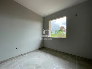 Ambiente interno com piso de cerâmica claro e parede branca.