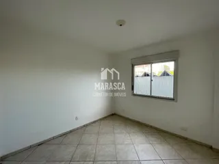 Uma sala interna com piso de cerâmica e janela.