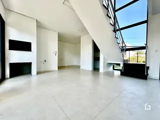 Espaço interno amplo com escadaria e grande janela em uma residência.