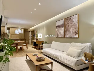 Sala de estar ampla com sofá branco e decoração moderna em um apartamento.