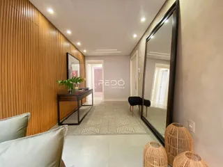 Hall de entrada com painéis de madeira e espelho grande.