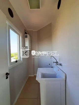 Banheiro com pia branca e janela em um ambiente interno.