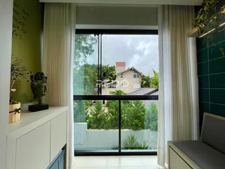 Vista da sala de estar com portas de vidro que dão para um jardim.