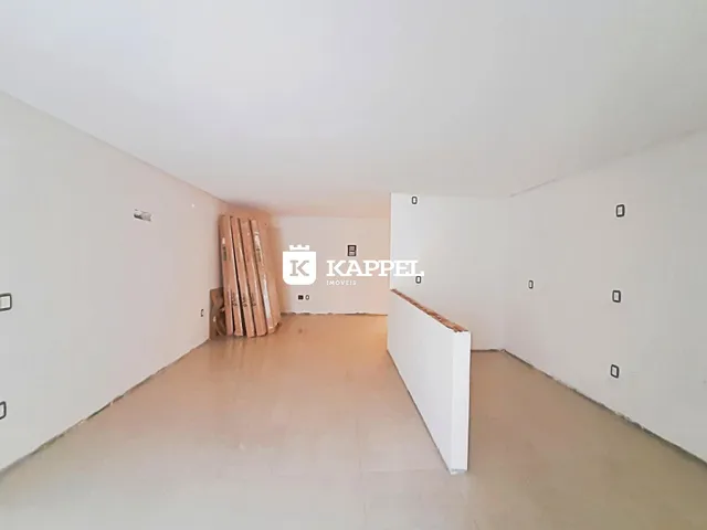 Hall de entrada com paredes brancas e materiais de construção visíveis.
