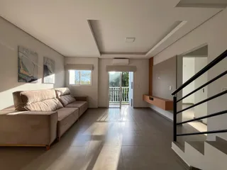 Sala de estar com sofá e piso de madeira clara.