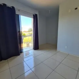 Ambiente interno com piso de cerâmica e portas de vidro que dão acesso ao exterior.