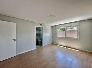 A sala de estar apresenta um piso de madeira clara e paredes cinzentas.