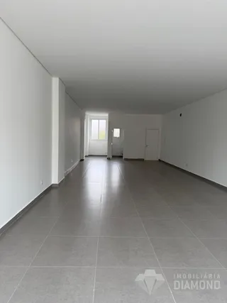 Corredor interno com piso de cerâmica e paredes brancas.