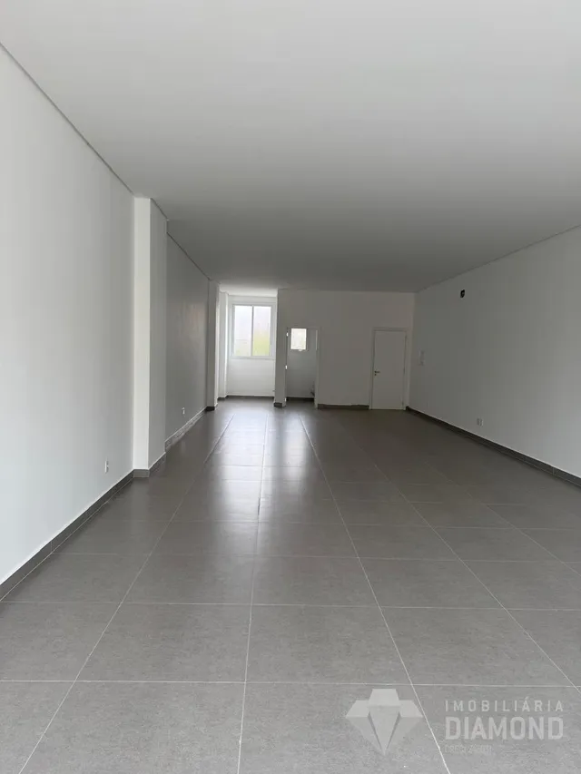 Corredor interno com piso de cerâmica e paredes brancas.