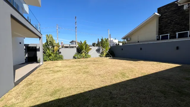Vista externa de um quintal gramado com muro de divisa em uma residência em Lajeado.