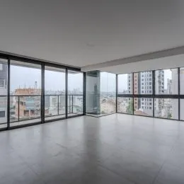 Sala ampla com grandes janelas que oferecem vista da cidade.