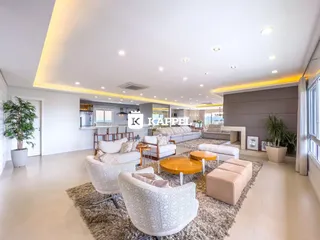 Sala de estar moderna com sofás e iluminação embutida em um apartamento.