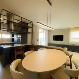 Foto de uma mesa de jantar redonda com cadeiras em um ambiente interno.