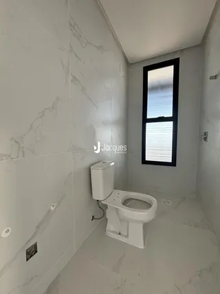 Foto de um banheiro com revestimento de mármore branco.