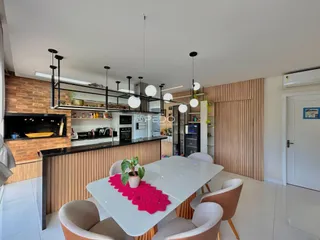 A sala de jantar e cozinha apresenta um design moderno com iluminação pendente.