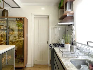 Cozinha com bancada de mármore e eletrodomésticos em ambiente interno.