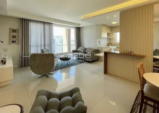 Sala de estar moderna com piso de porcelanato claro e grandes janelas.