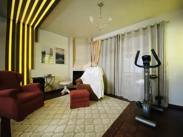Sala de estar com lareira e cortinas claras.
