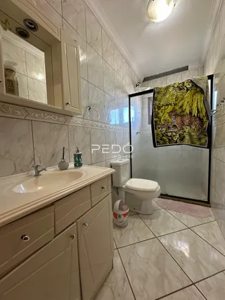 Foto de um banheiro com revestimento de azulejo branco.