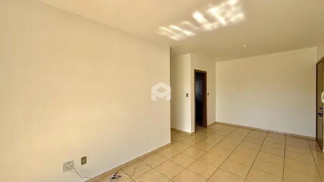 Interior de uma sala com paredes brancas e piso de cerâmica clara.