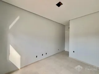 Vista ampla de um ambiente interno com paredes brancas e piso claro.