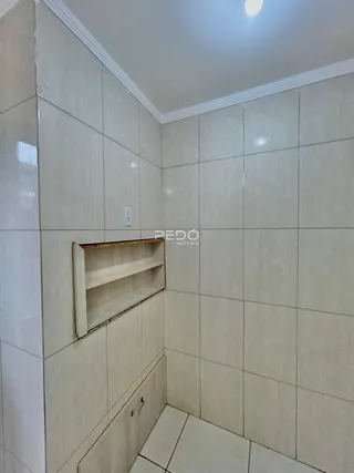 Parede de um ambiente com revestimento cerâmico claro.