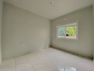 A sala apresenta piso de cerâmica e uma janela com vista para o exterior.