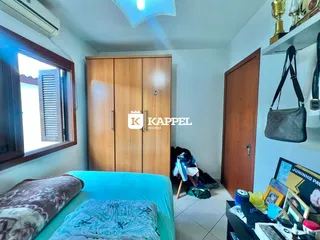 Quarto com cama azul e um grande guarda-roupa de madeira.