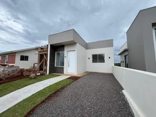 Fachada de uma casa moderna em Lajeado, Brasil, com jardim e acesso de cascalho.