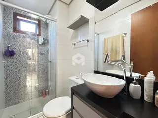 Banheiro moderno com box de vidro e revestimento cerâmico.